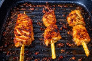 צלייה של שיפודי הסלמון על מחבת פסים